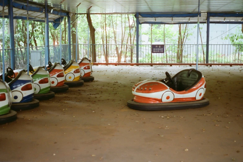 a row of bumper cars lined up under a tent