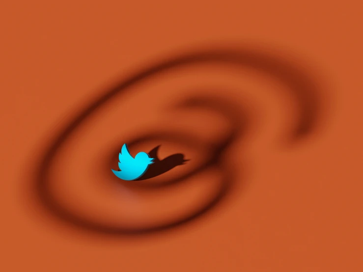 the blue bird is flying in front of an orange spiral