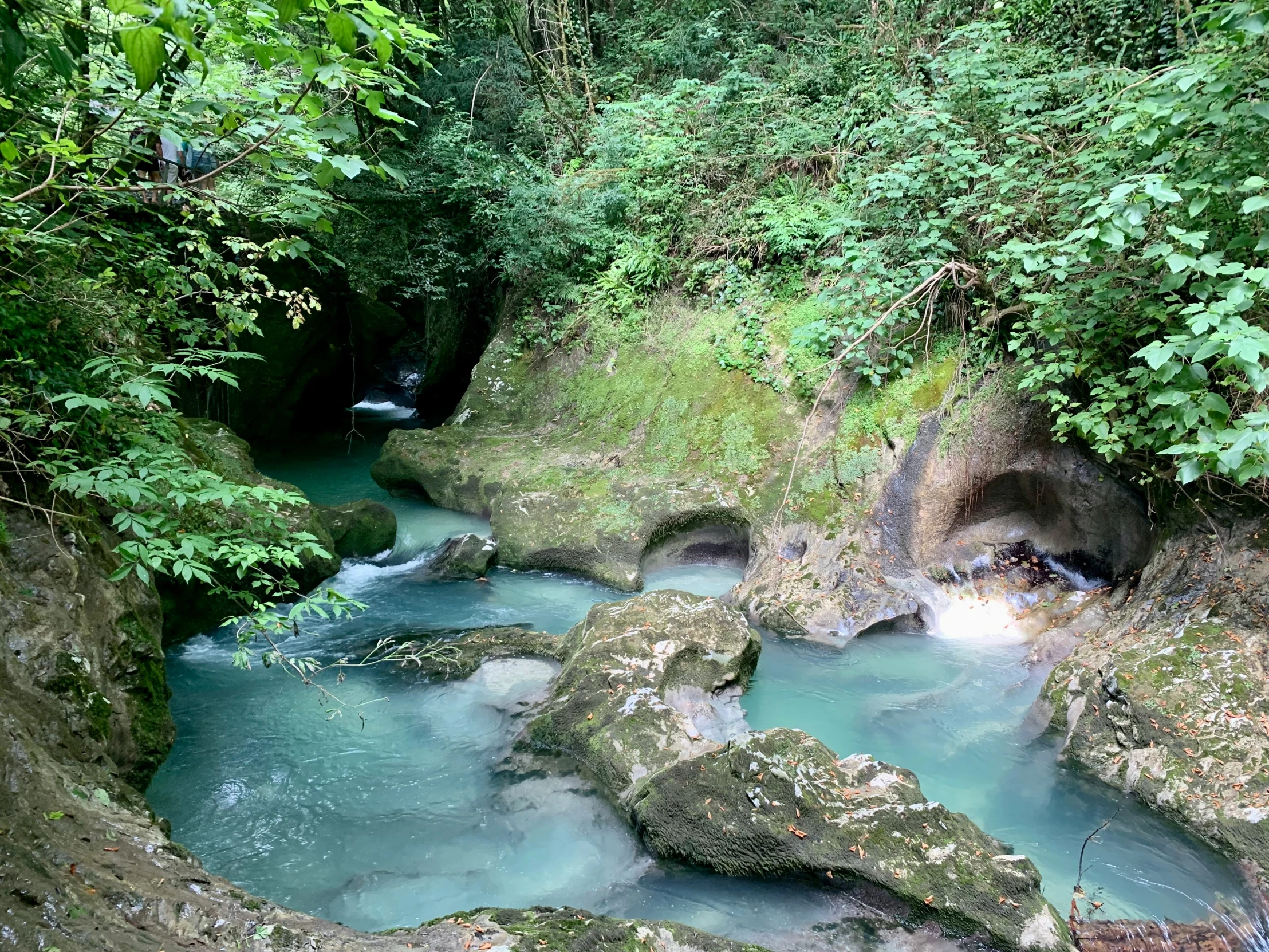 the blue water is running through a narrow creek