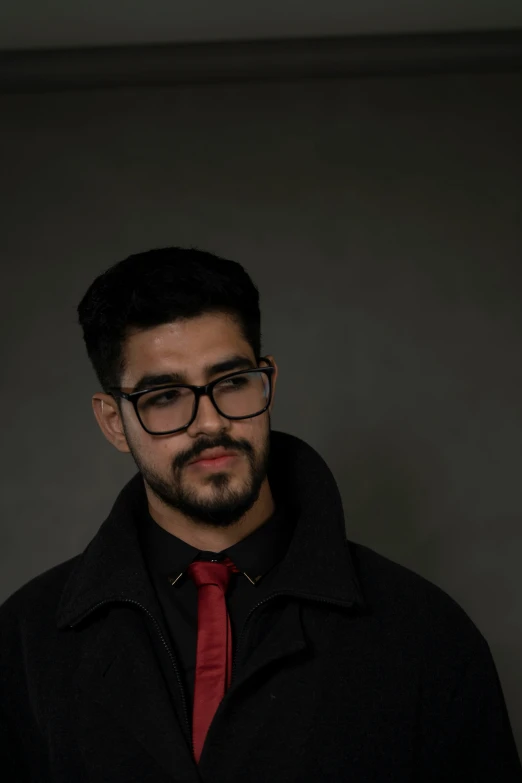 a young man wearing glasses and a red tie