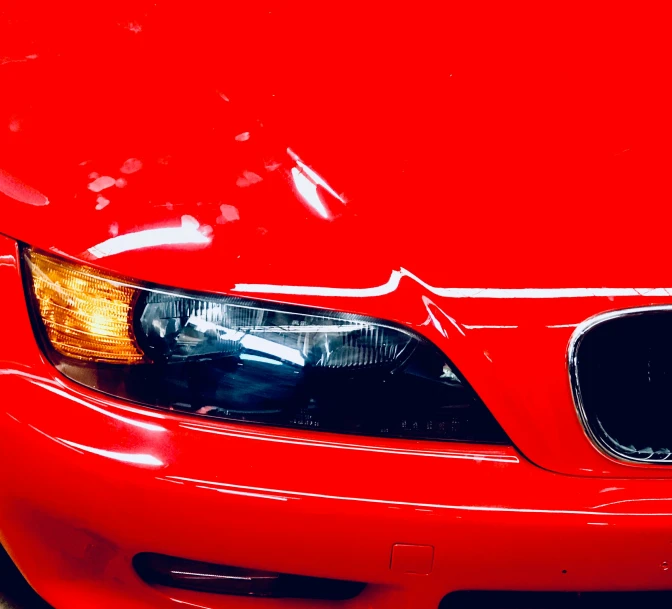 an orange car that is parked close together