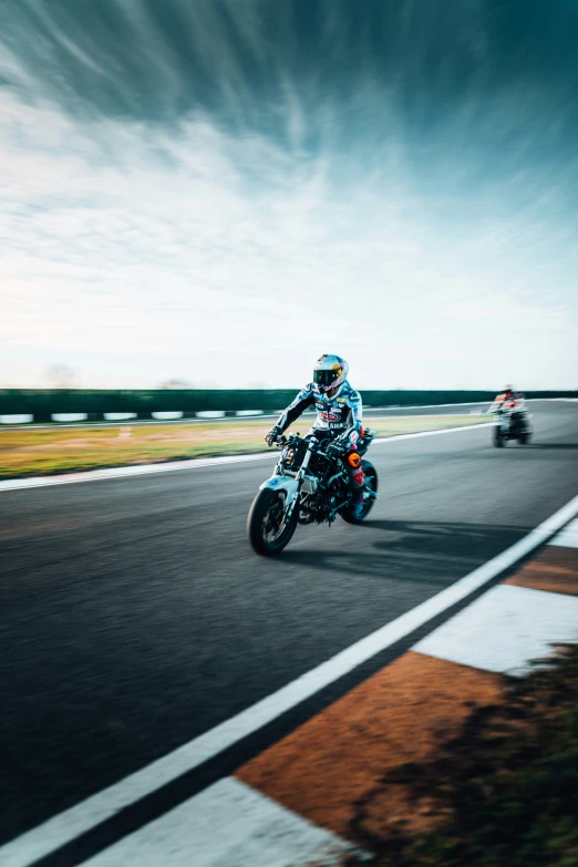 a couple of people are racing motorcycles around a track