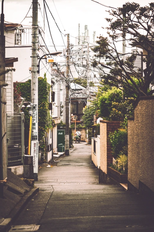 a narrow residential area with power lines overhead