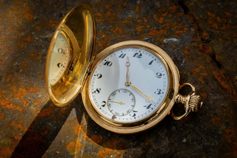 an old pocket watch sits on a stone