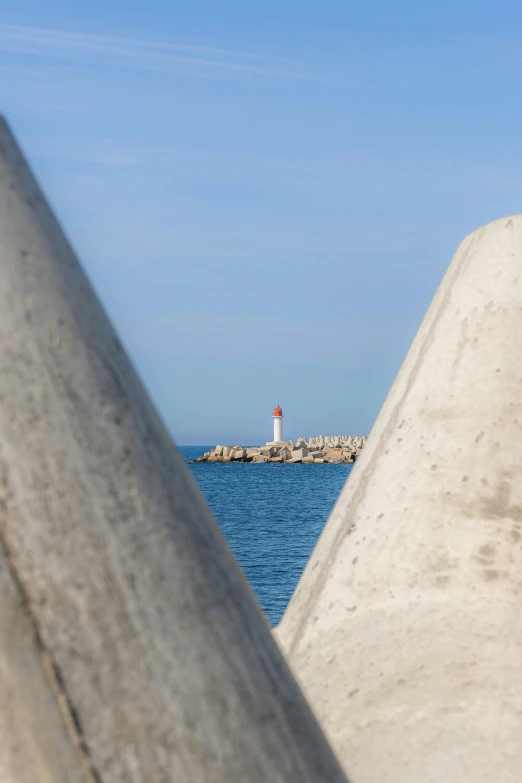 a lighthouse is seen off of the rocks by the water