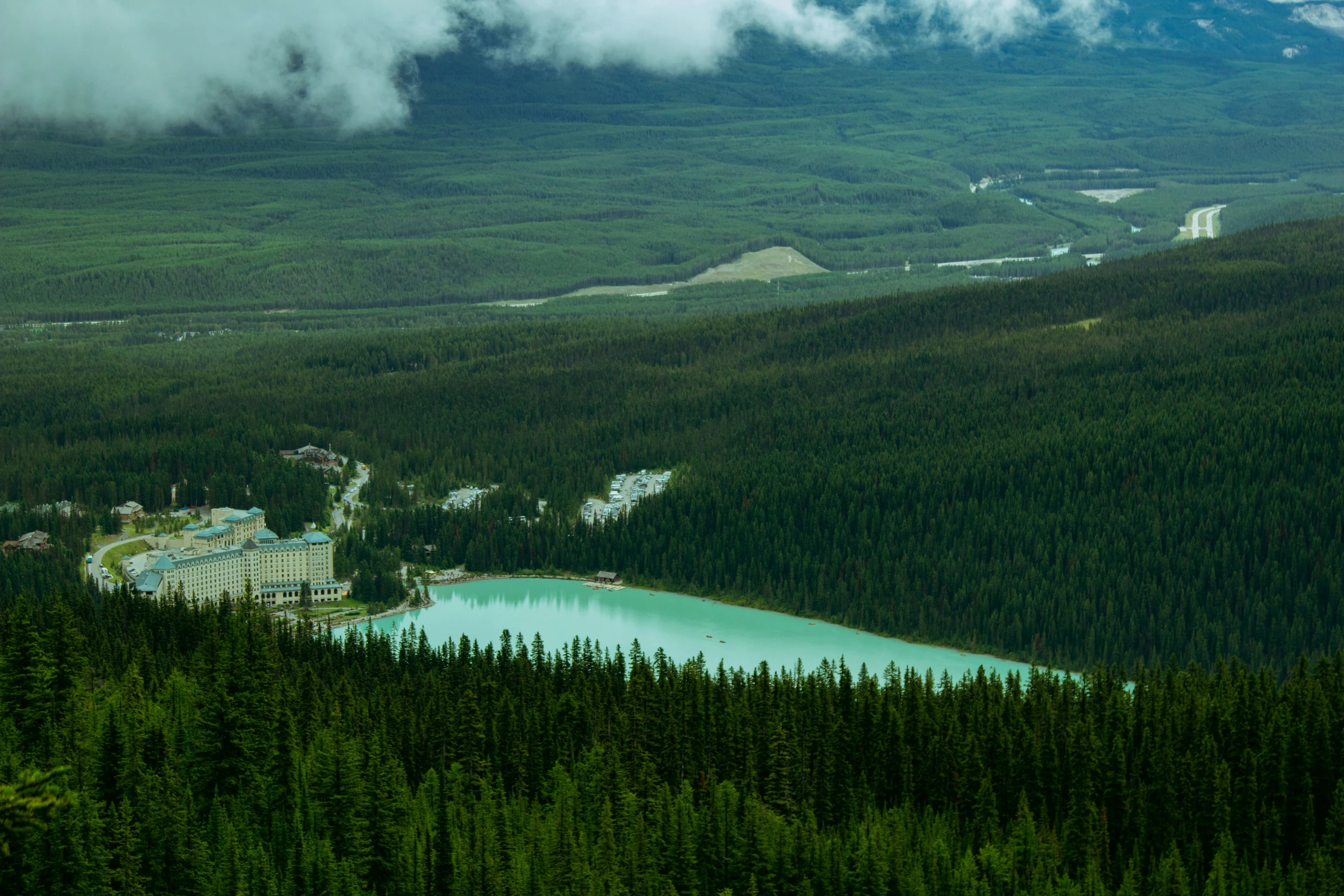 a lake in a forest with mountains in the background