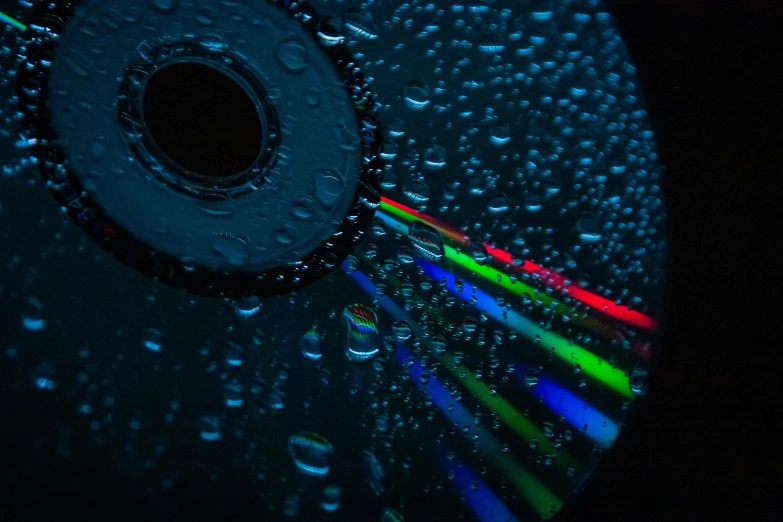 a black, black background with rain drops that are colorfully lit