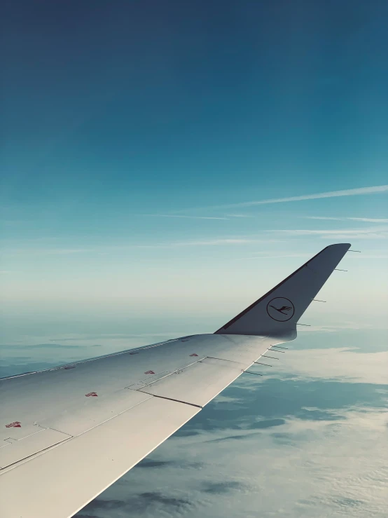 the wing of an airplane flying over clouds