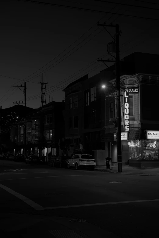 a dark po shows an empty street with cars parked at the curb