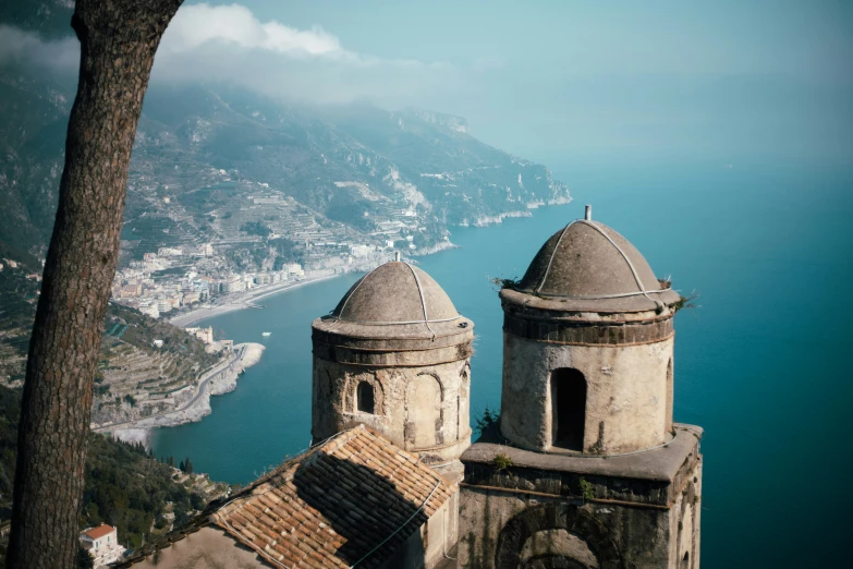 a stone building overlooks an ocean filled town