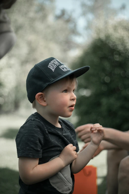 a  in a baseball cap is sitting on a park bench