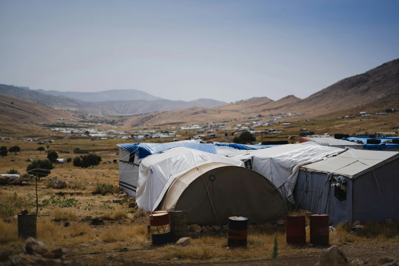 tents are set up on the side of a field