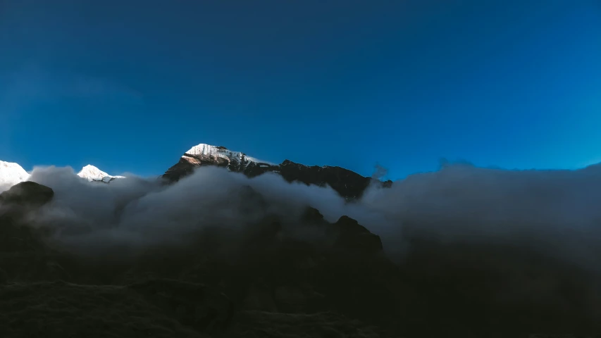 the clouds are moving through a mountain top