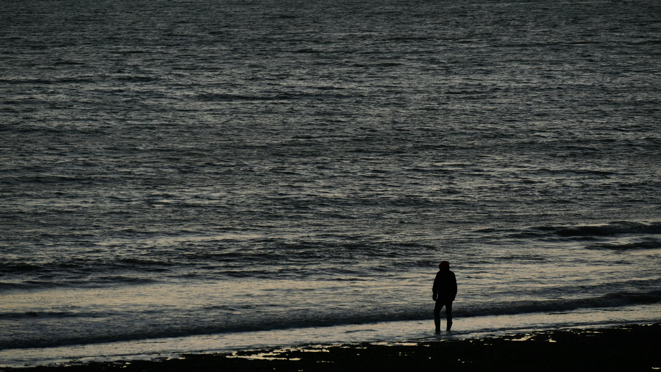 a person that is standing in the sand