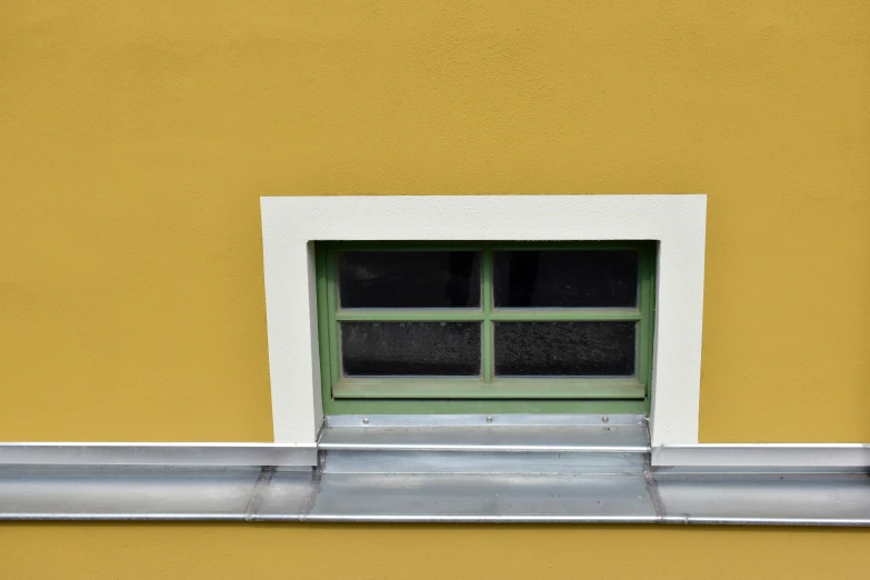 a bright yellow building with white trim and green window