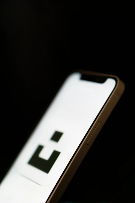 a cell phone sitting next to a dark background