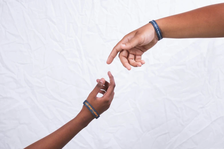 a close up of two people reaching towards each other