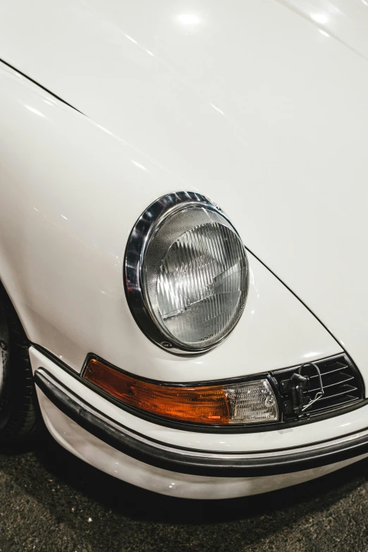 close up of front light of a white vintage sports car