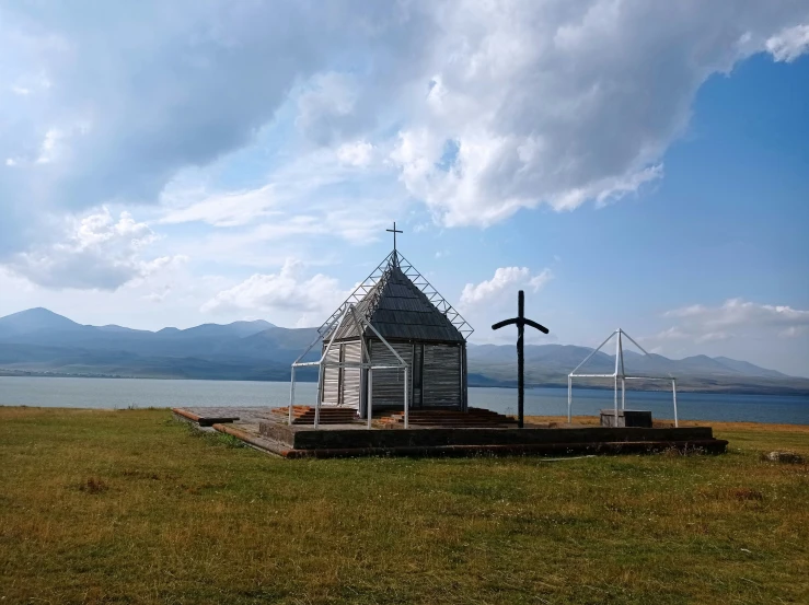 a wooden church standing on top of a lush green field