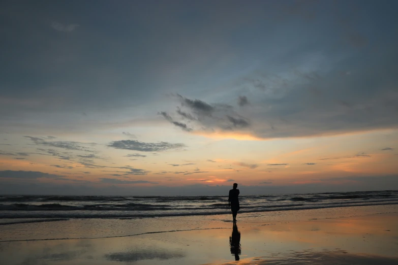 a person is walking in the sand at the beach