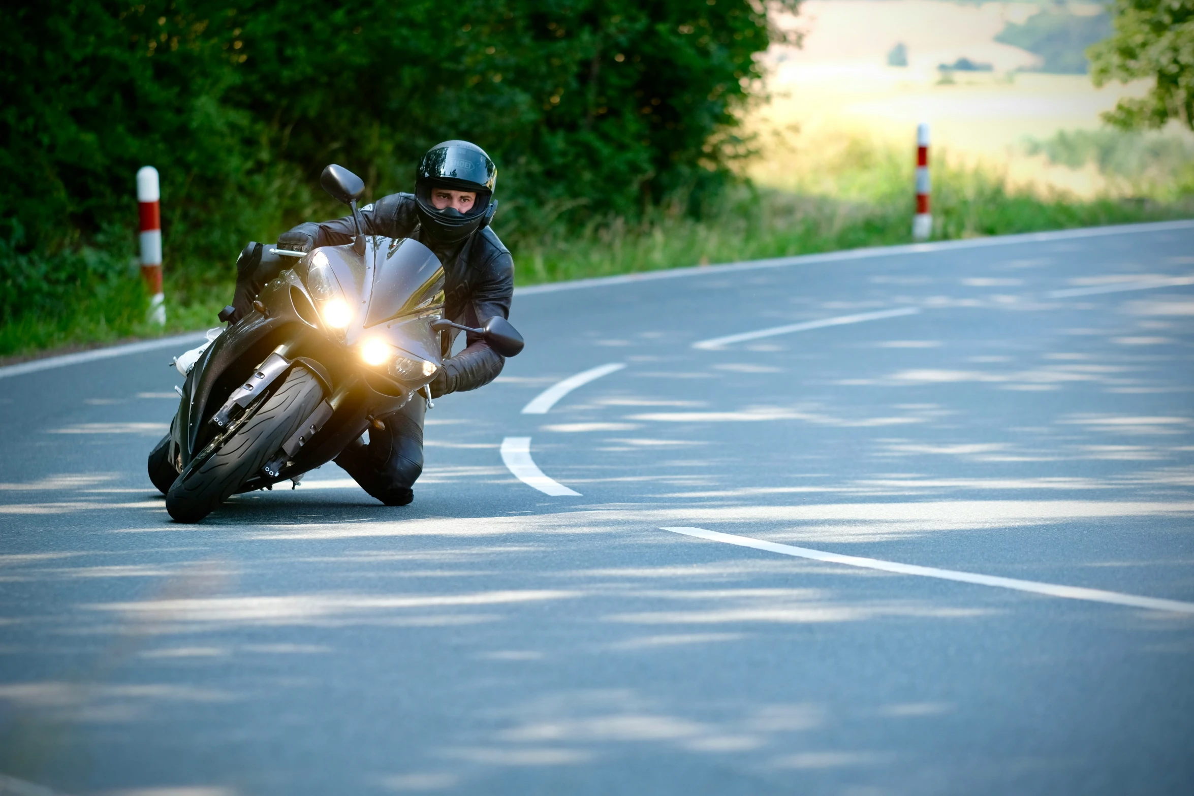 a person riding a motorcycle on the road with a light on