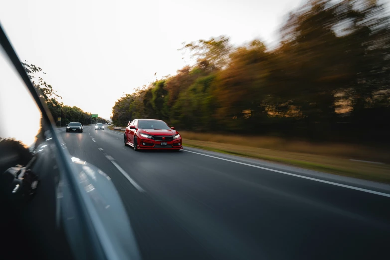 two cars driving down the road in motion