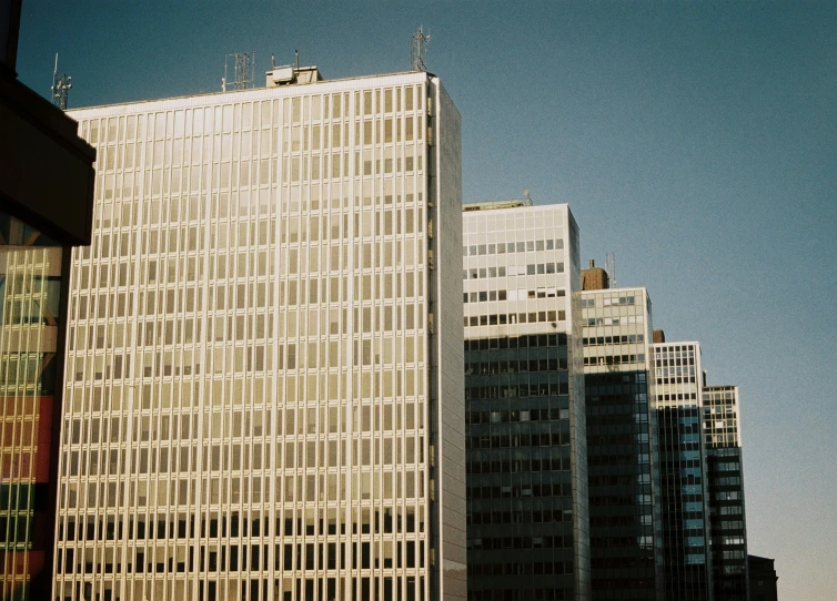 a tall building with many windows near other buildings