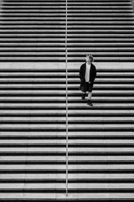 a man standing on the side of a tall building next to a wall