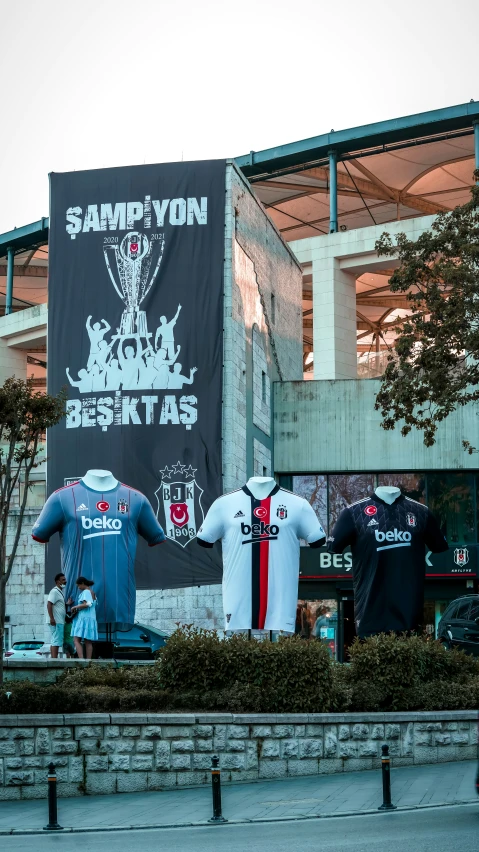 two football jerseys sitting on top of a bench next to a building