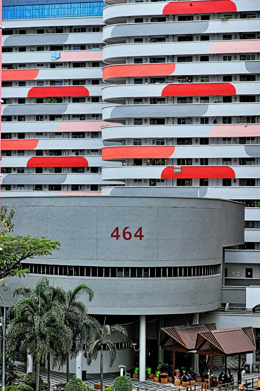 a tall building next to trees with large red roof windows