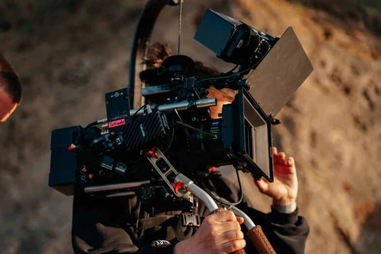 a man is holding a video camera near a wall