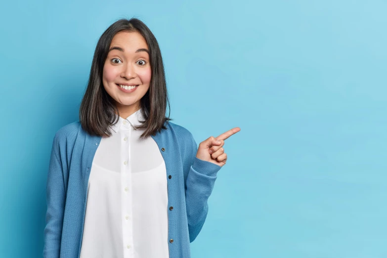 young woman pointing at soing while smiling