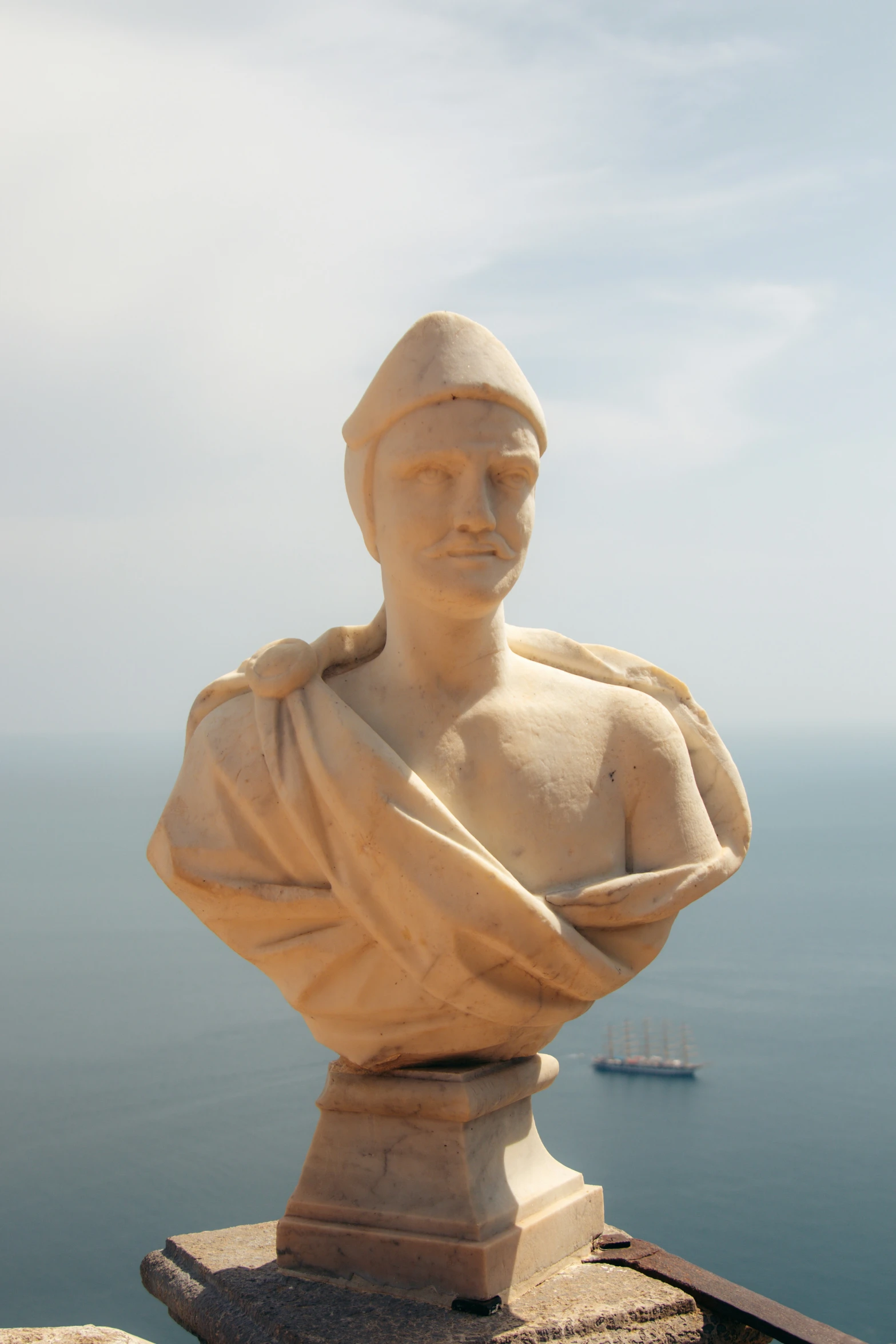 a sculpture with a ship in the background