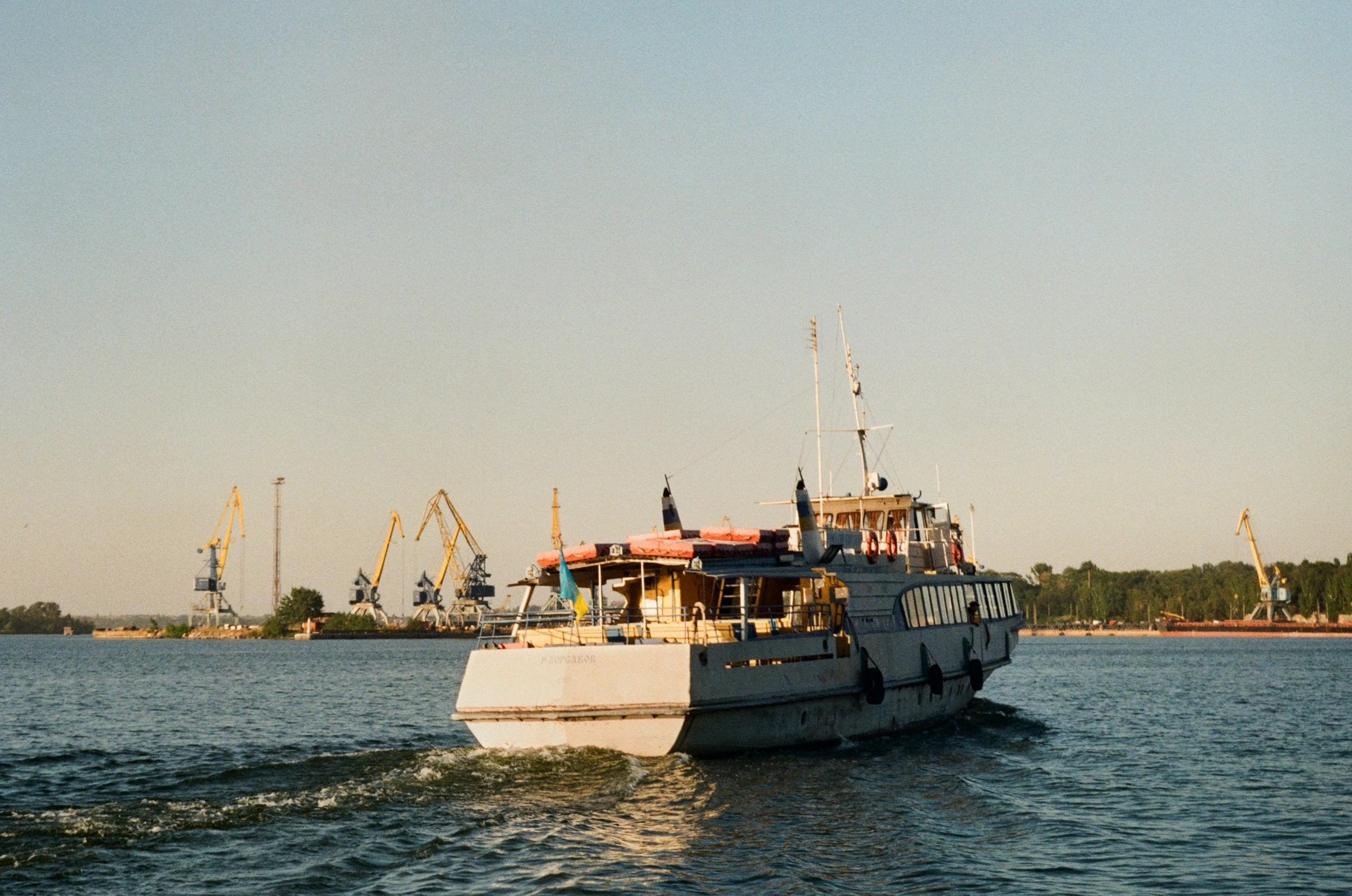 a big white boat is going down a river