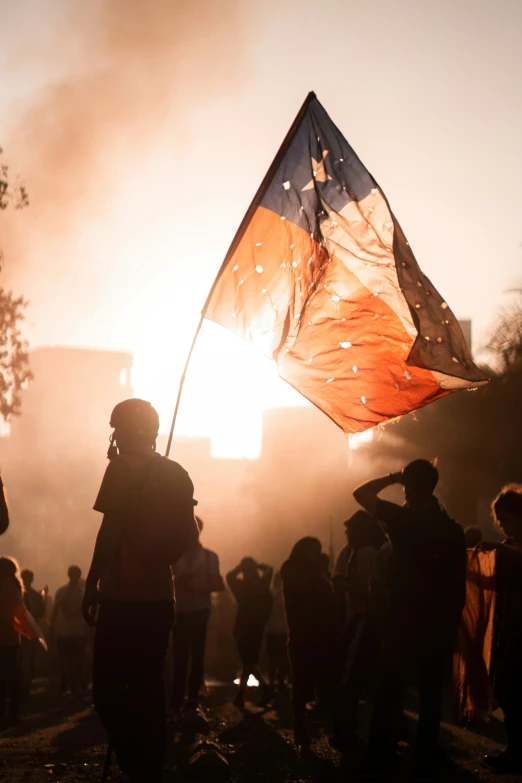 people with flags standing around and lighting the candles