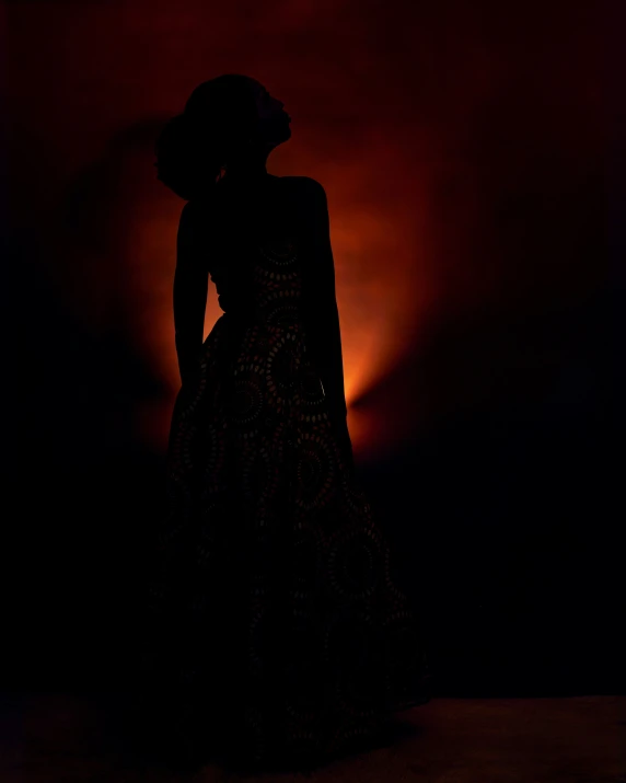 the silhouette of a woman in a long black dress
