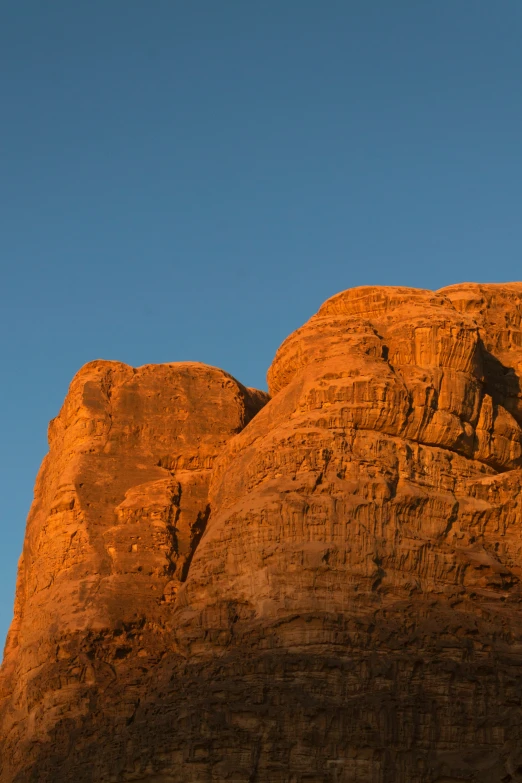 a mountain with a very tall red rock formation with a bird in the middle