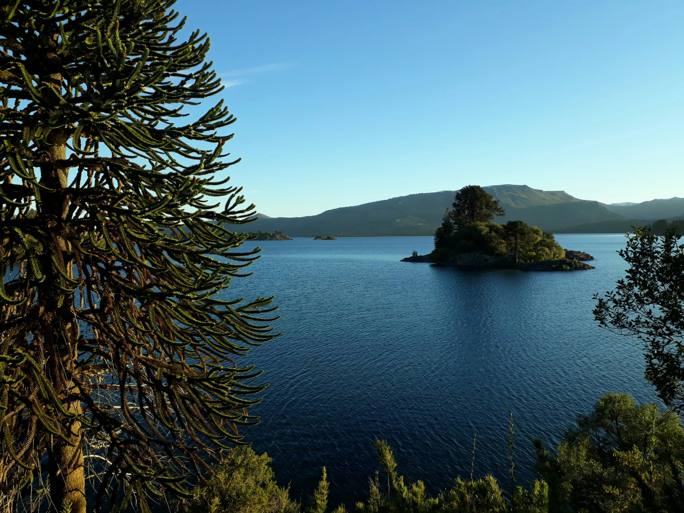 an island is in the middle of some blue water