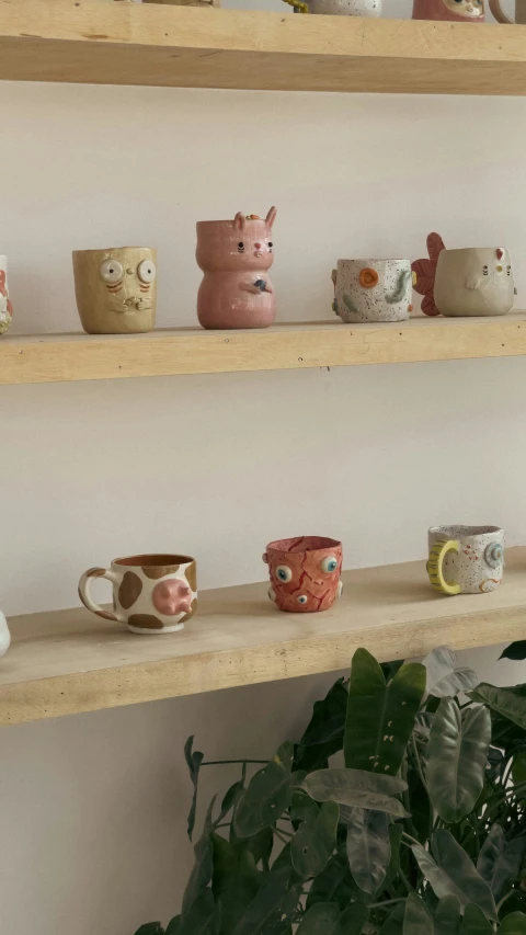 there are several different cups lined up on the shelves