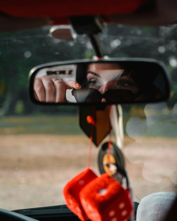 the reflection of a woman in a car's side view mirror