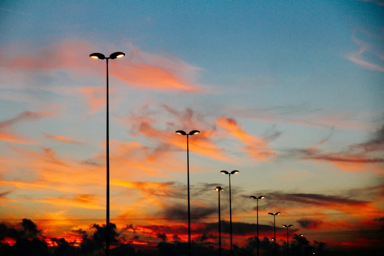 the sun is rising over some street lights