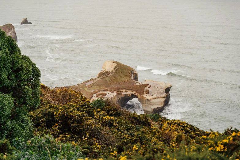 a rock formation near the ocean is seen from the shore