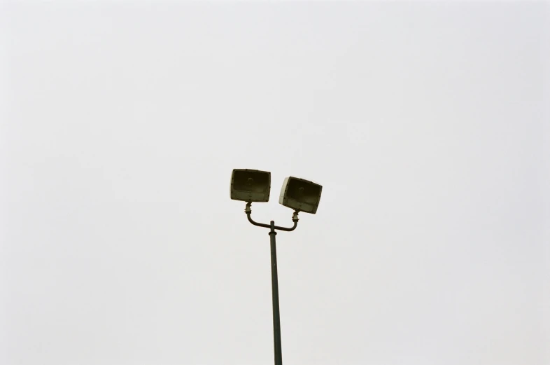 a couple of light posts sitting under a gray sky