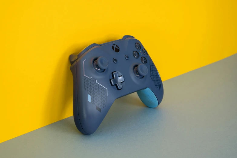 a computer game controller sits on a blue and gray surface