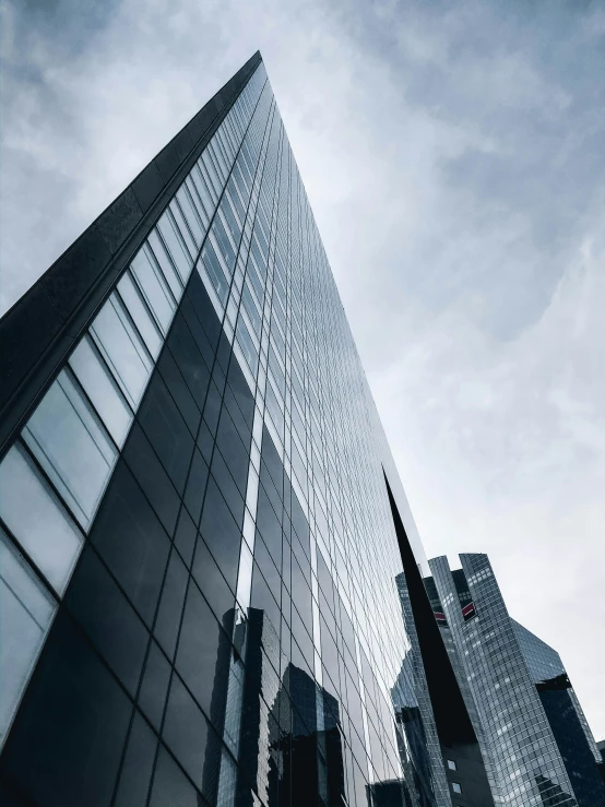 the tops of three tall buildings are shown against a blue sky