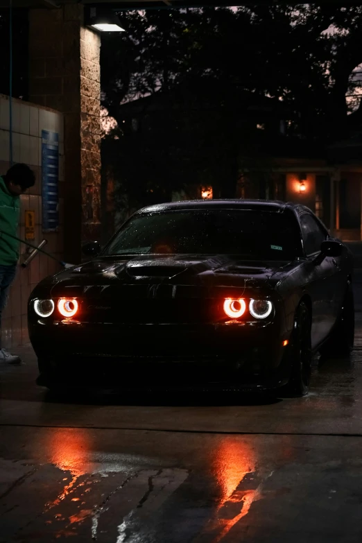 a person washes his car with an electric pressure wash machine