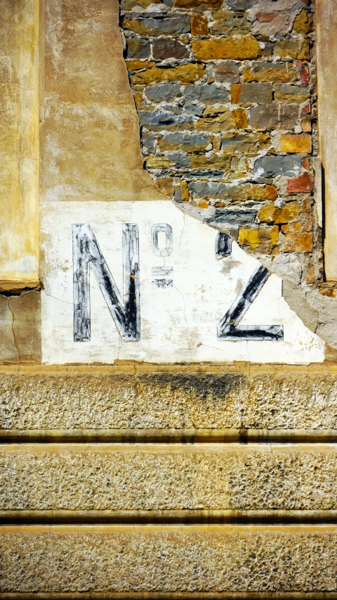 a street sign is near a wall of rubble