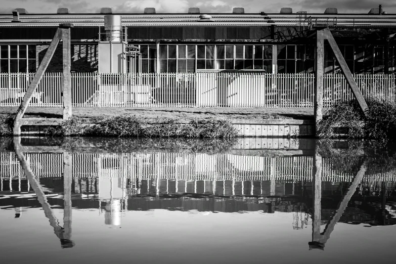 a building reflecting in a still pond on a rainy day