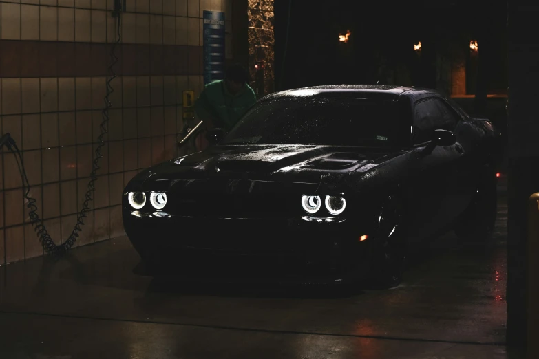 a black dodge car is sitting in the garage