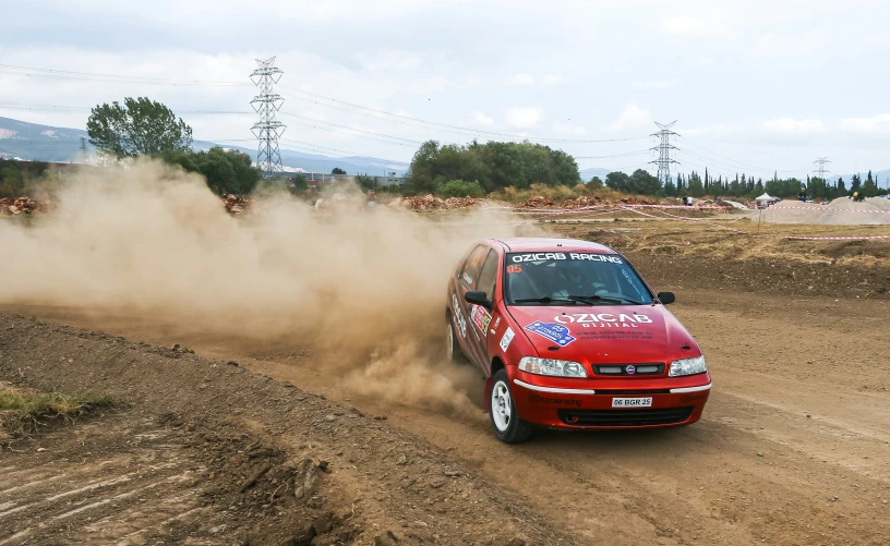 a car on the dirt road with dust coming off it